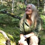 Petra Ellora Cau Wetterholm sitter i naturen och ler